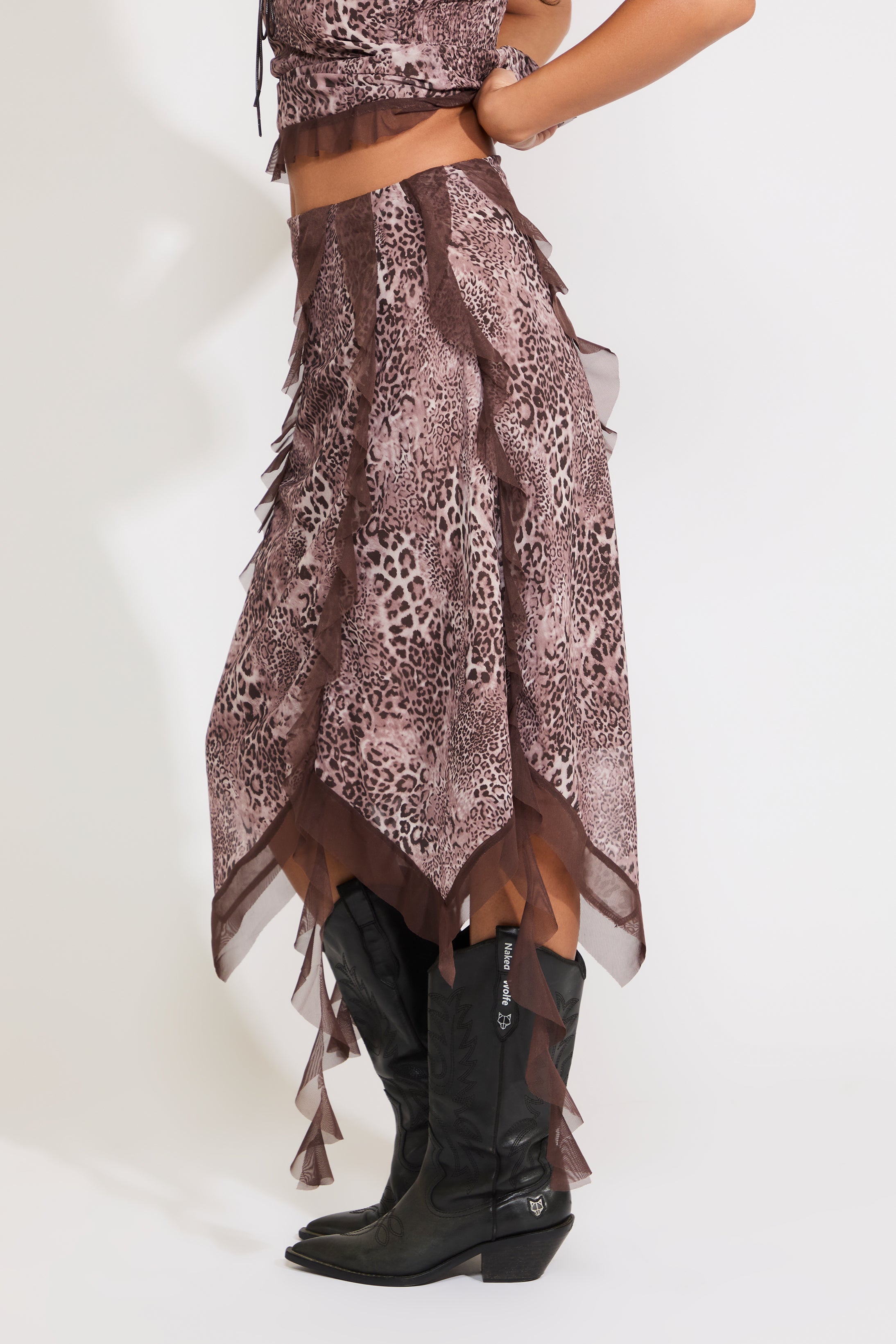 Model is wearing an asymmetric hem contrast ruffle leopard print midi skirt with a matching top on a white background.