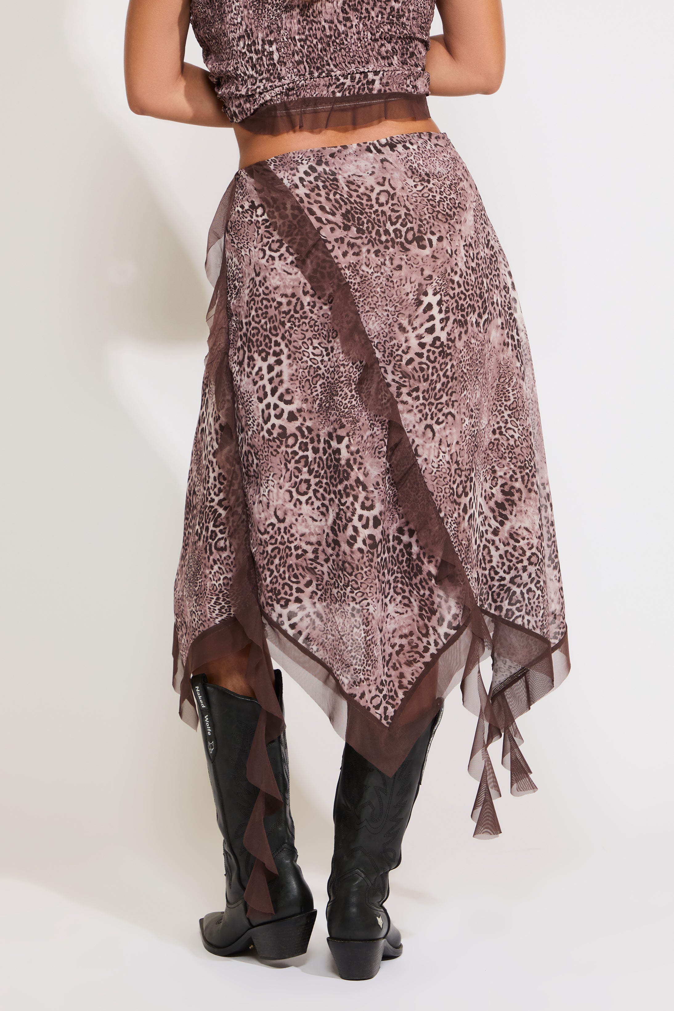 Model is wearing an asymmetric hem contrast ruffle leopard print midi skirt with a matching top on a white background.