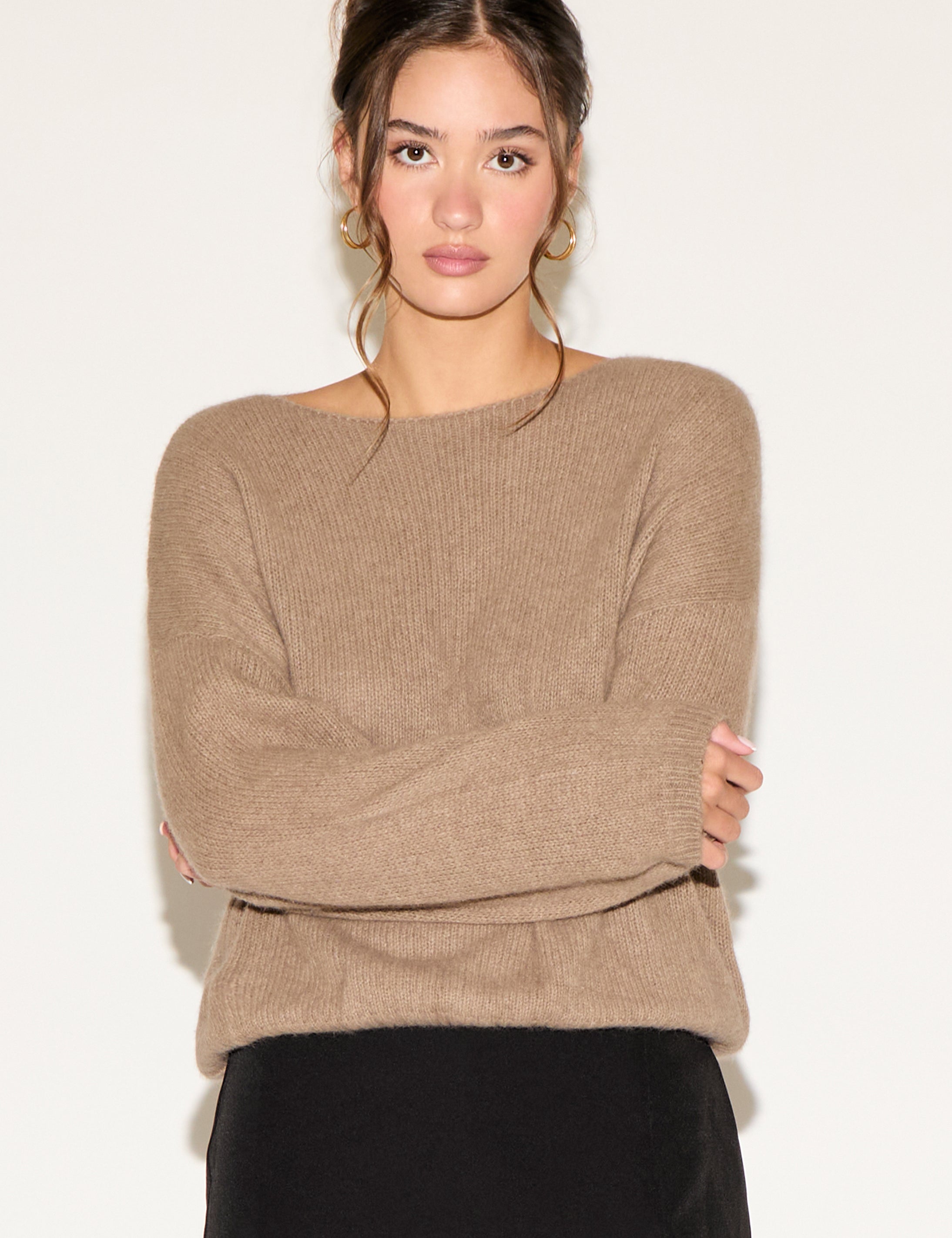 Woman wearing a beige sweater against a white background
