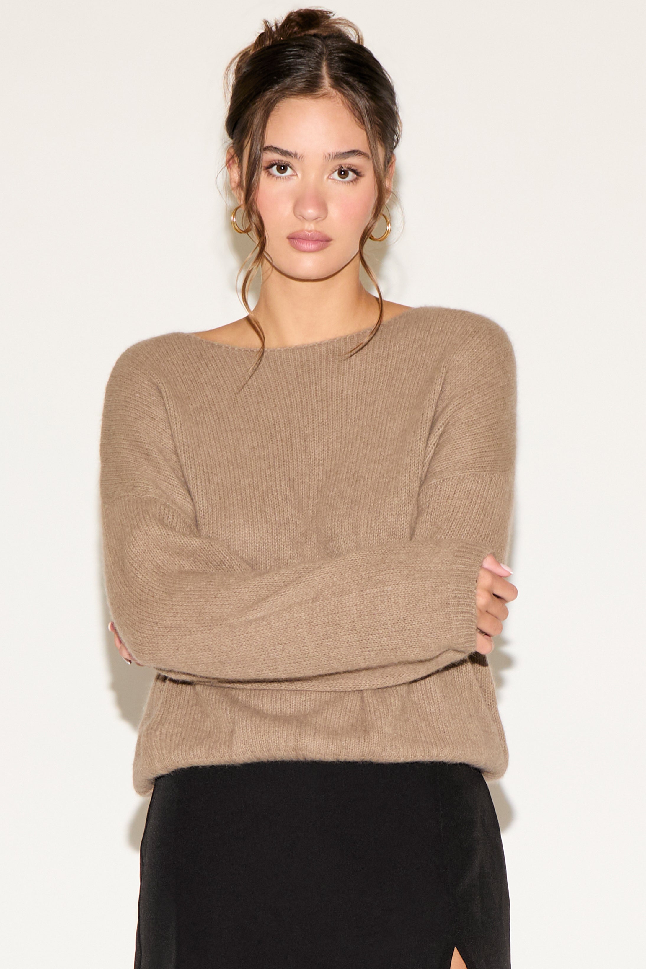 Woman wearing a beige sweater against a white background