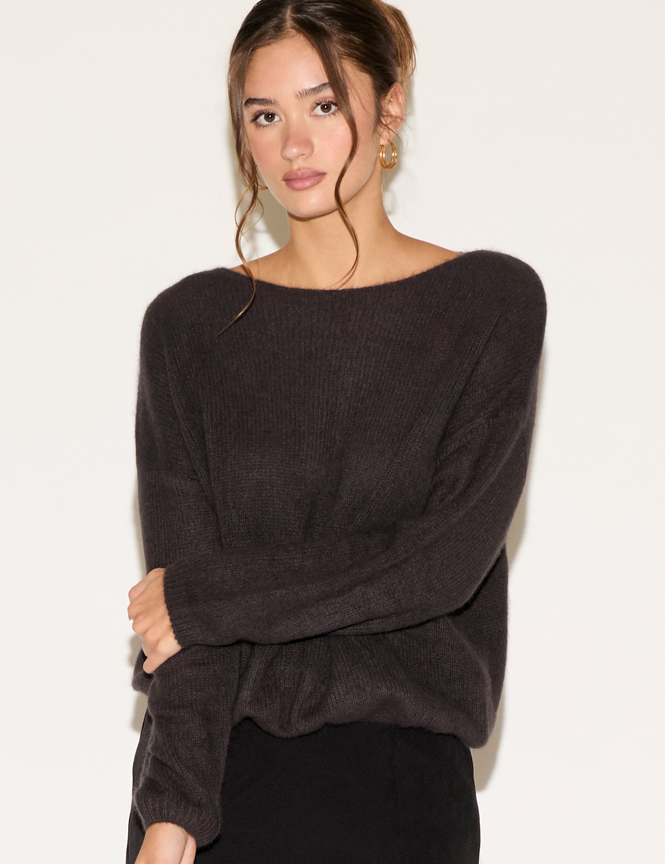 Woman wearing a dark gray sweater against a white background