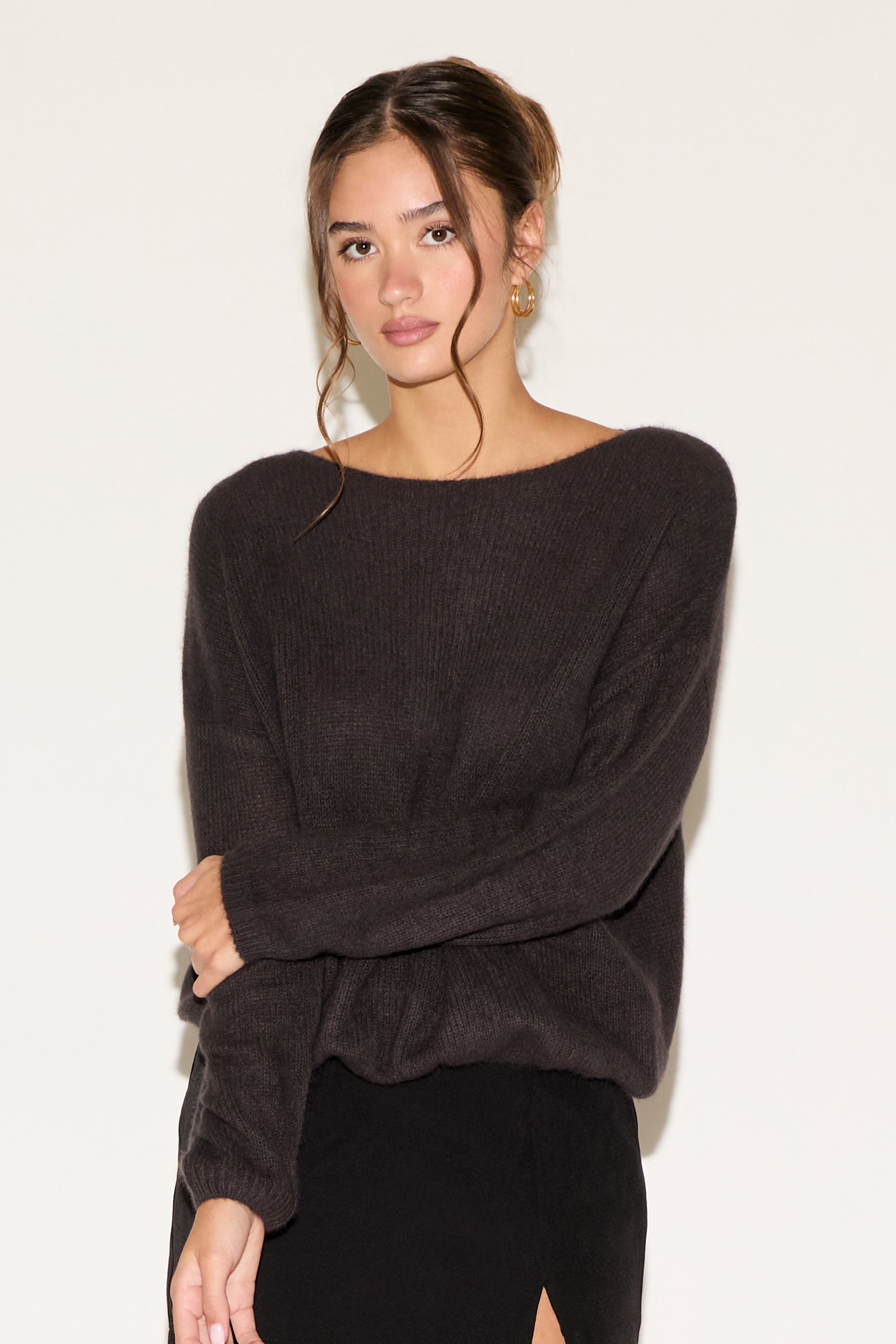 Woman wearing a dark gray sweater against a white background