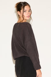 Woman wearing a dark brown sweater against a white background