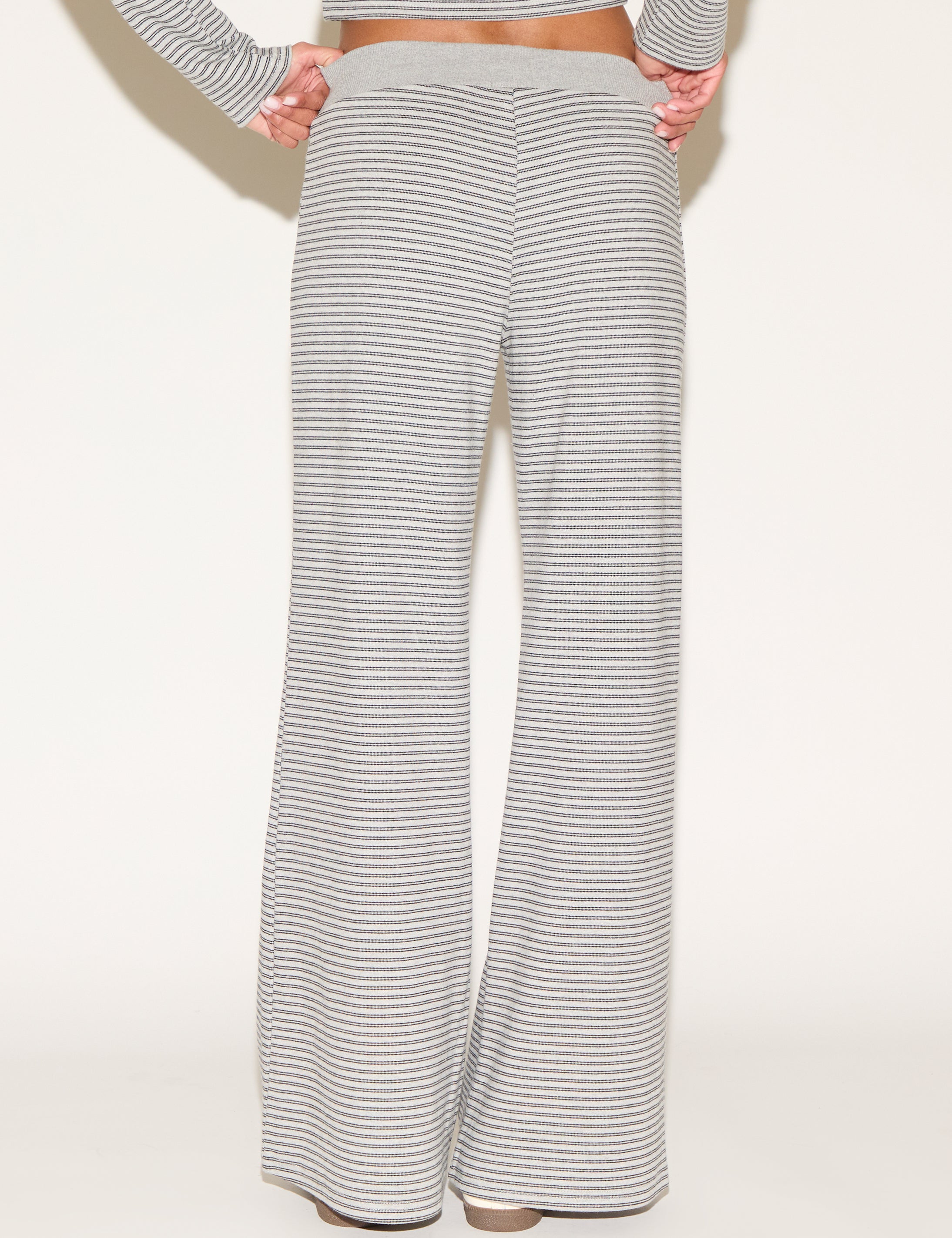 Back view of gray-and-white striped wide-leg lounge pants featuring a soft elastic waistband and relaxed fit, shown from waist to hem against a clean, neutral studio background.