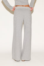 Back view of gray-and-white striped wide-leg lounge pants featuring a soft elastic waistband and relaxed fit, shown from waist to hem against a clean, neutral studio background.
