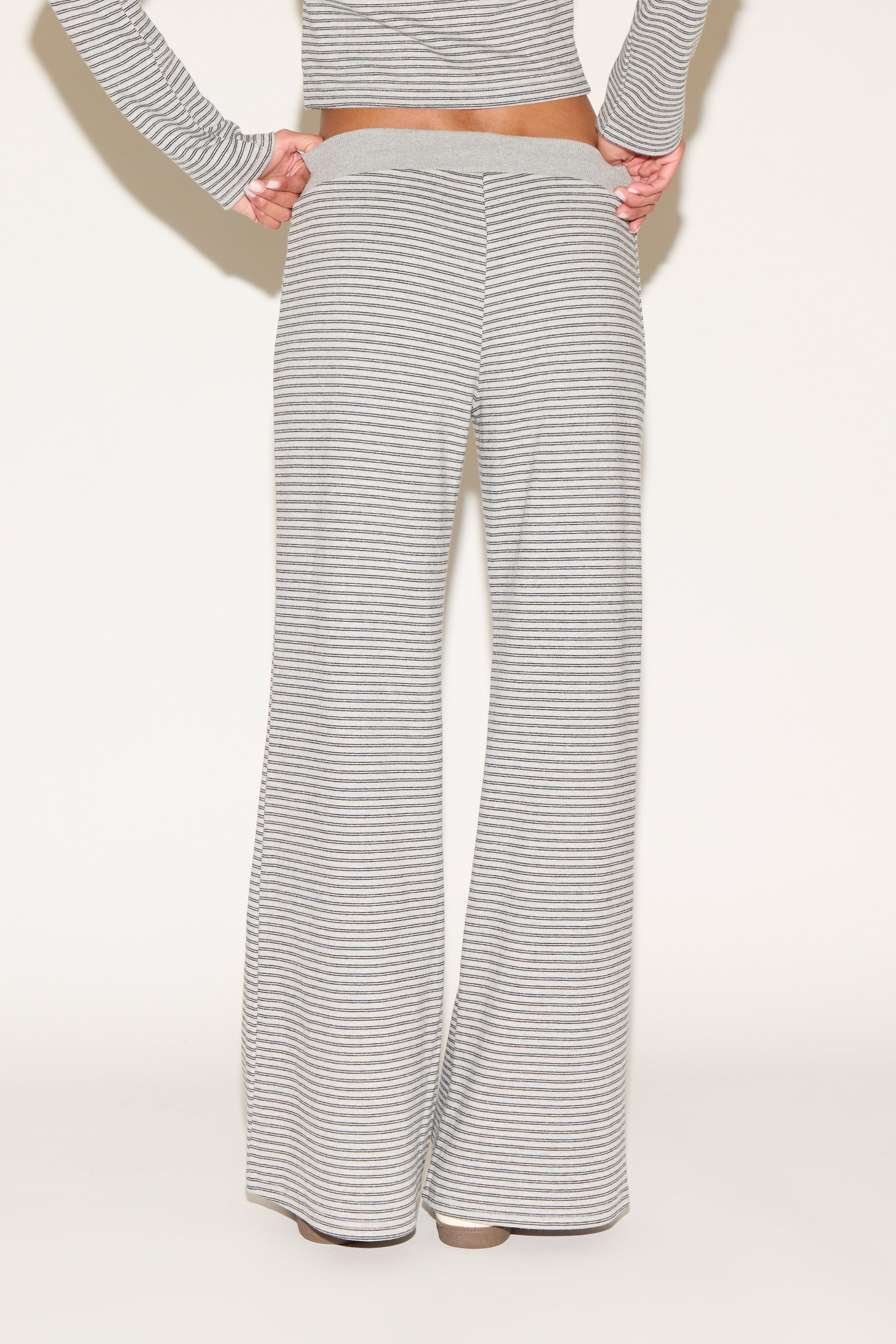 Back view of gray-and-white striped wide-leg lounge pants featuring a soft elastic waistband and relaxed fit, shown from waist to hem against a clean, neutral studio background.