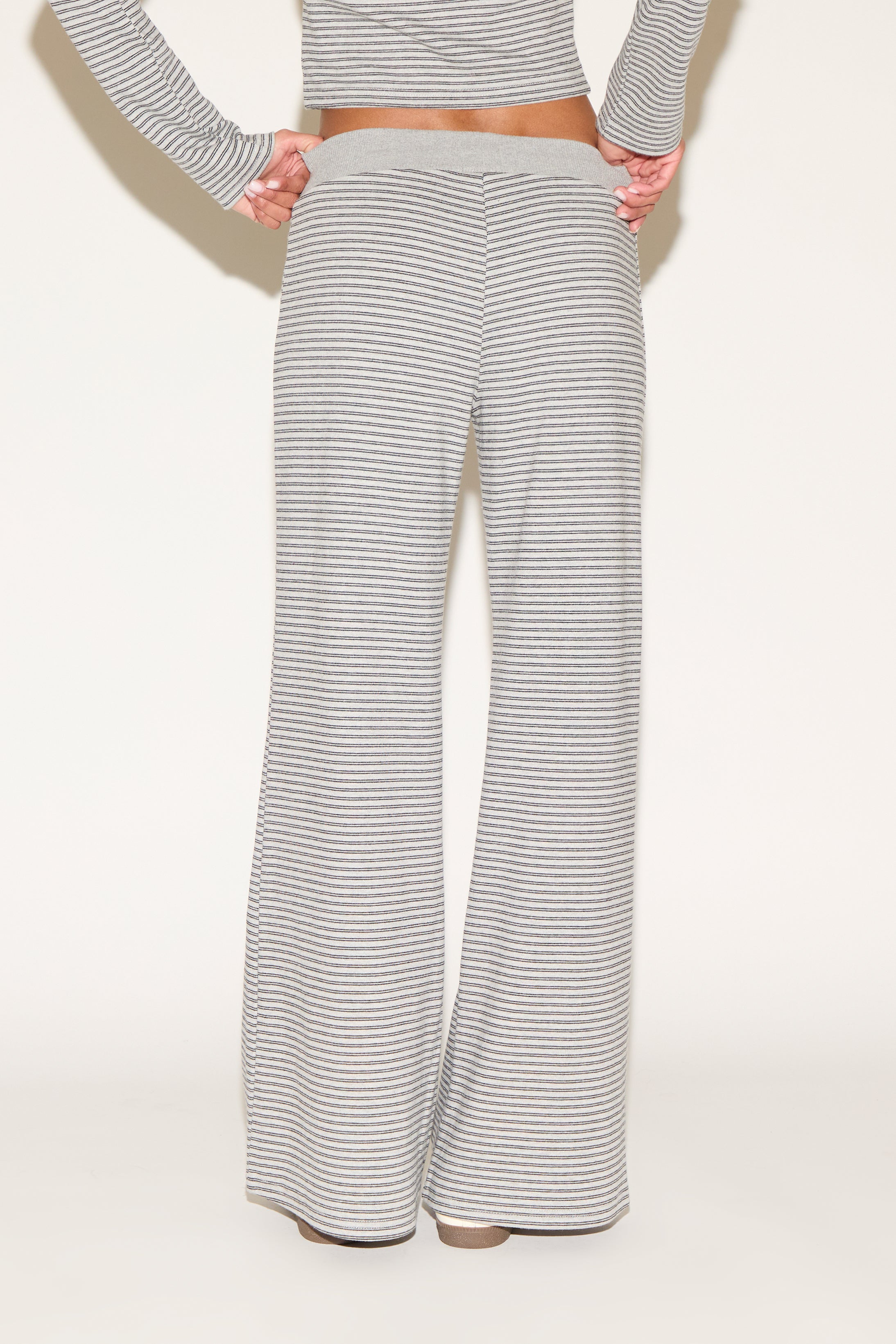 Back view of gray-and-white striped wide-leg lounge pants featuring a soft elastic waistband and relaxed fit, shown from waist to hem against a clean, neutral studio background.