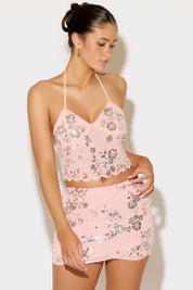 Woman wearing a pink floral two-piece set against a white background