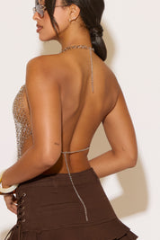Model is wearing a chainmail top with seashells on a white background