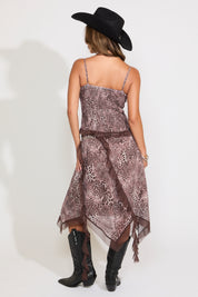Model is wearing an adjustable strap contrast hem leopard print top with a matching midi skirt on a white background.