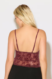 Model is wearing a ruched bust rose overlay cami top with lettuce hem with a black skirt on a white background. 