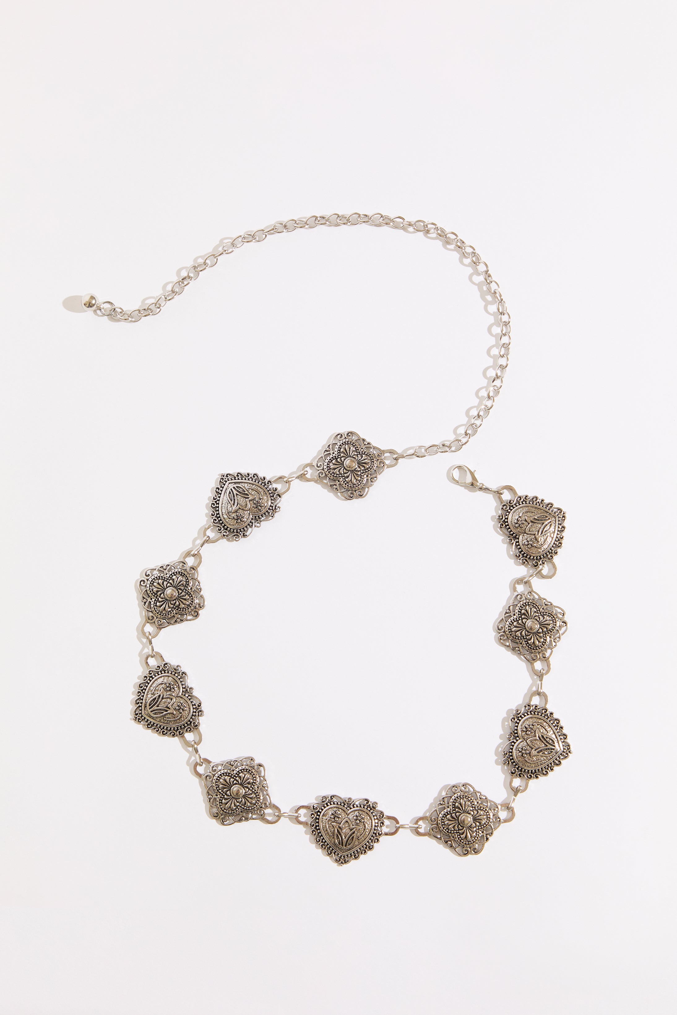 Silver necklace with floral designs on a white background