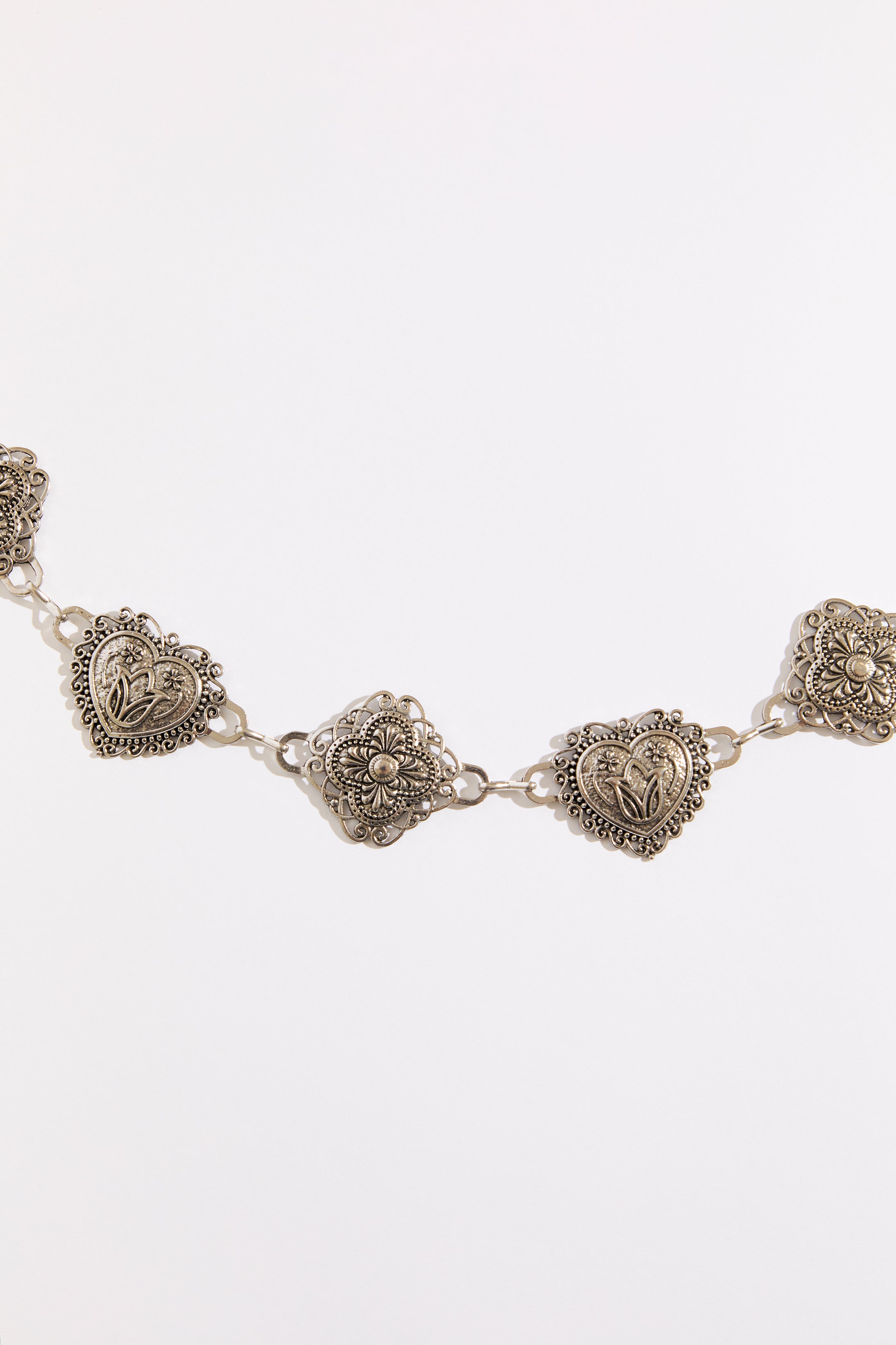 Silver bracelet with decorative heart-shaped charms on a white background