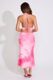 Model is wearing a pink TIE DYE COWL HALTER TOP & MESH MIDI SKIRT SET with pink heels on a white background.