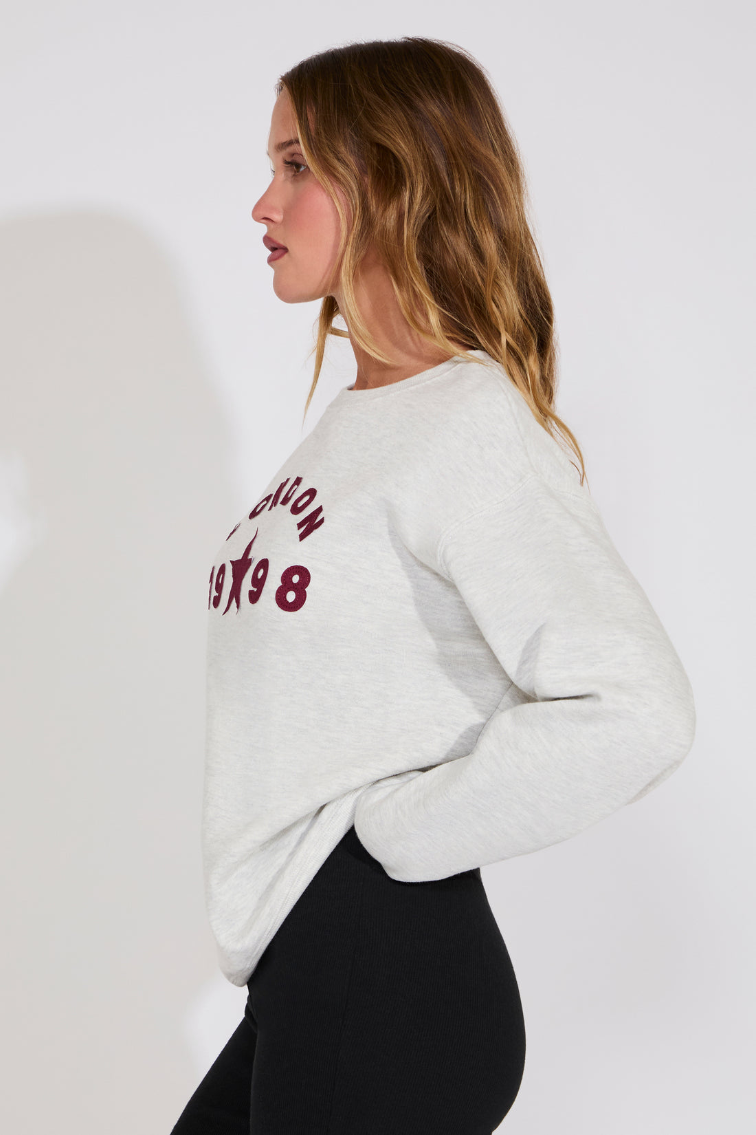 Woman wearing a light gray sweatshirt with text on a white background