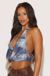 Woman wearing a blue tie-dye halter top against a white background