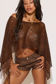 Woman wearing a brown mesh top and shorts with a white background