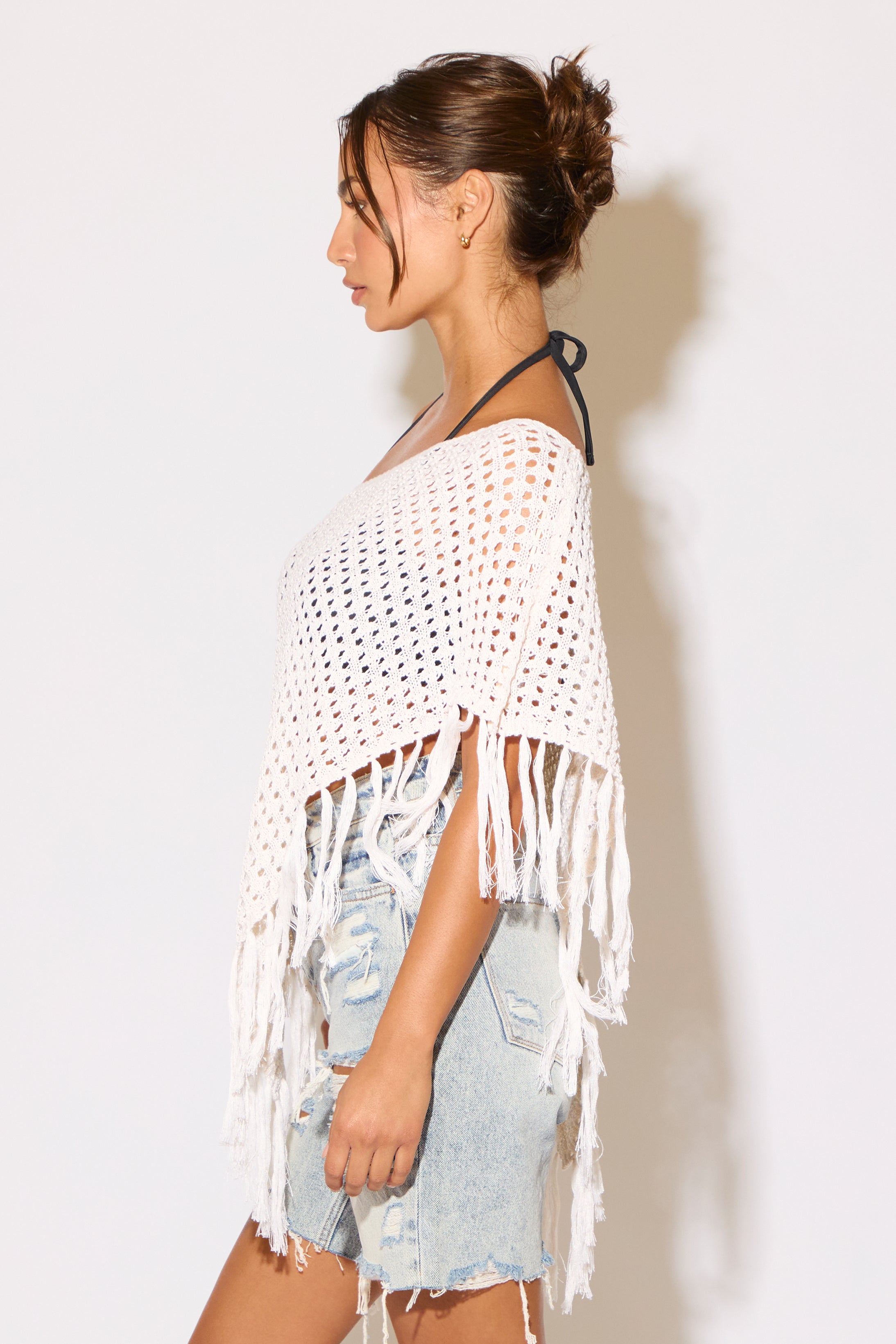 Model wearing a white shawl on a white background