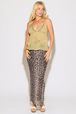 Model is wearing a sage tie neck and back chiffon beaded top with a leopard maxi skirt on a white background.