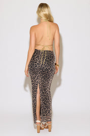 Model is wearing a sage tie neck and back chiffon beaded top with a leopard maxi skirt on a white background.