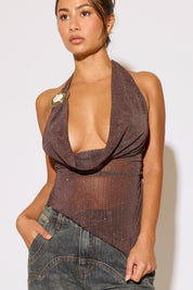 Woman wearing a brown halter top with a plain background
