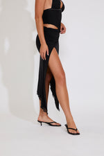 Black dress with a high slit on a white background