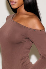 Brown off-shoulder top with studded details on a plain background