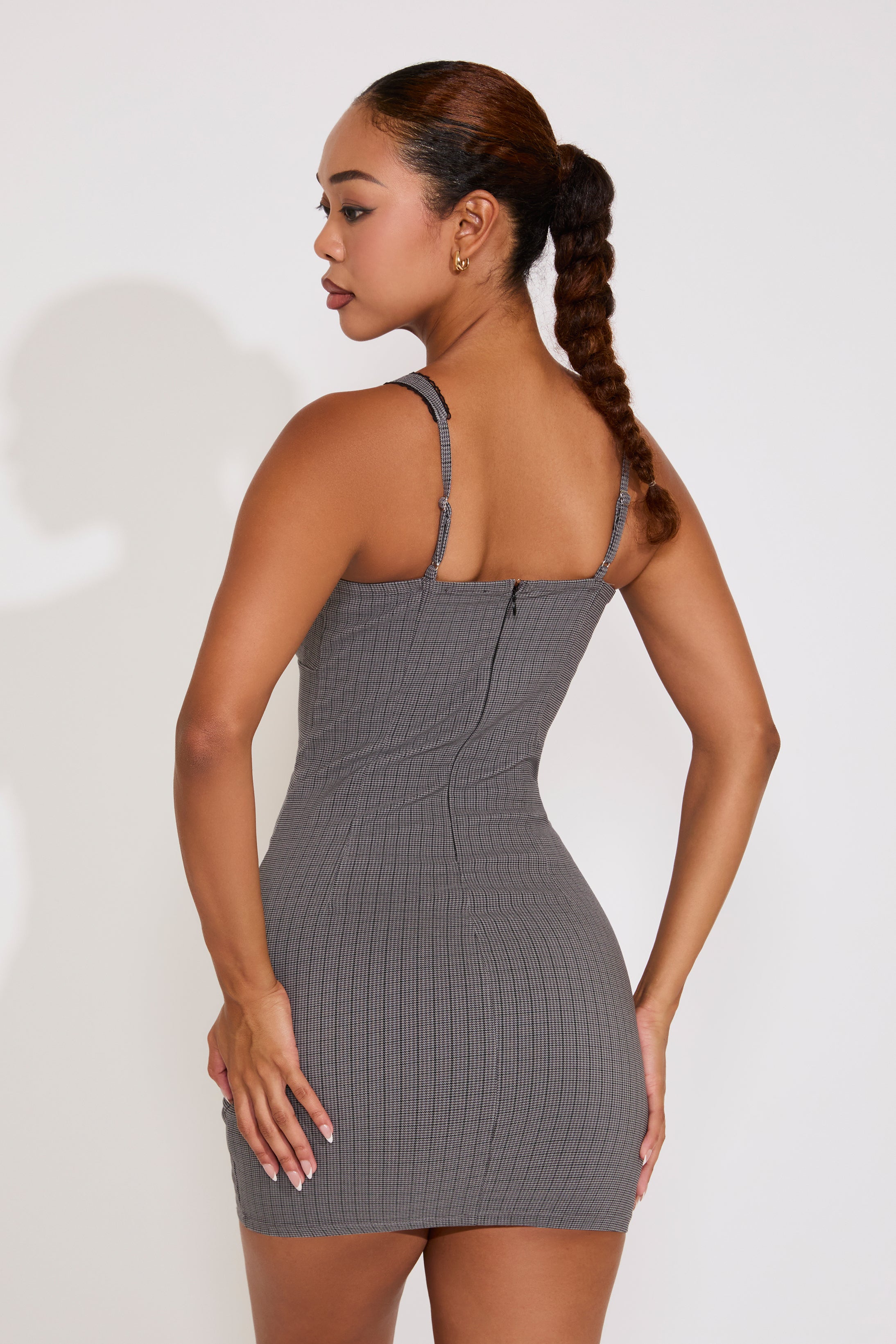 Woman wearing a gray ribbed dress against a white background