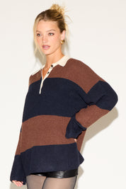 Woman wearing a brown and navy striped sweater on a white background
