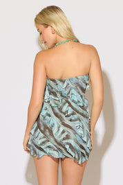 Model is wearing a blue and brown paint print mesh bias ruffles strapless mini dress on a white background.