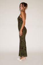 Woman wearing a green floral dress on a white background