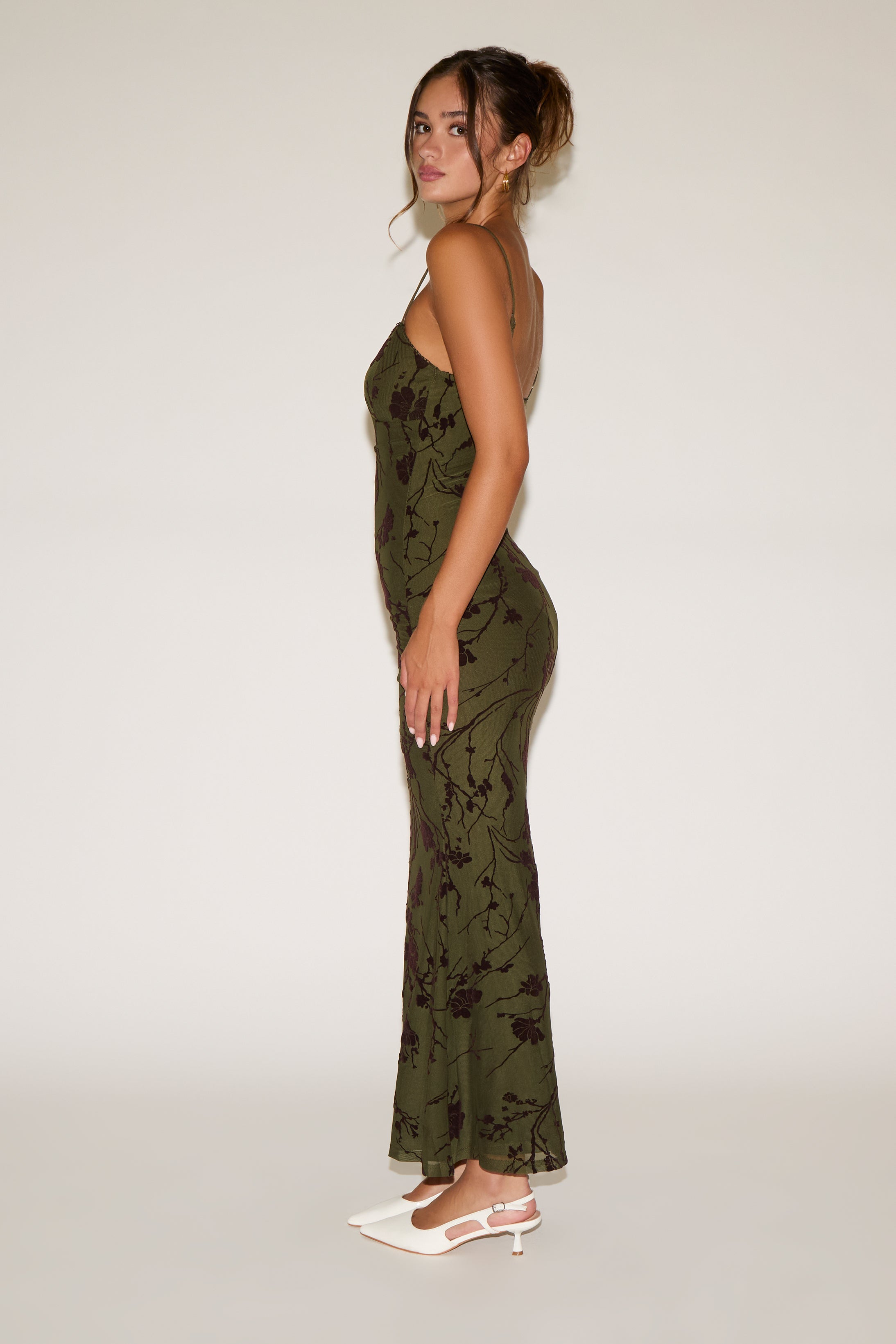 Woman wearing a green floral dress on a white background