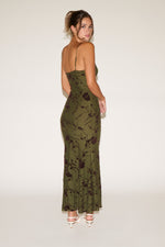 Woman wearing a green floral dress on a white background
