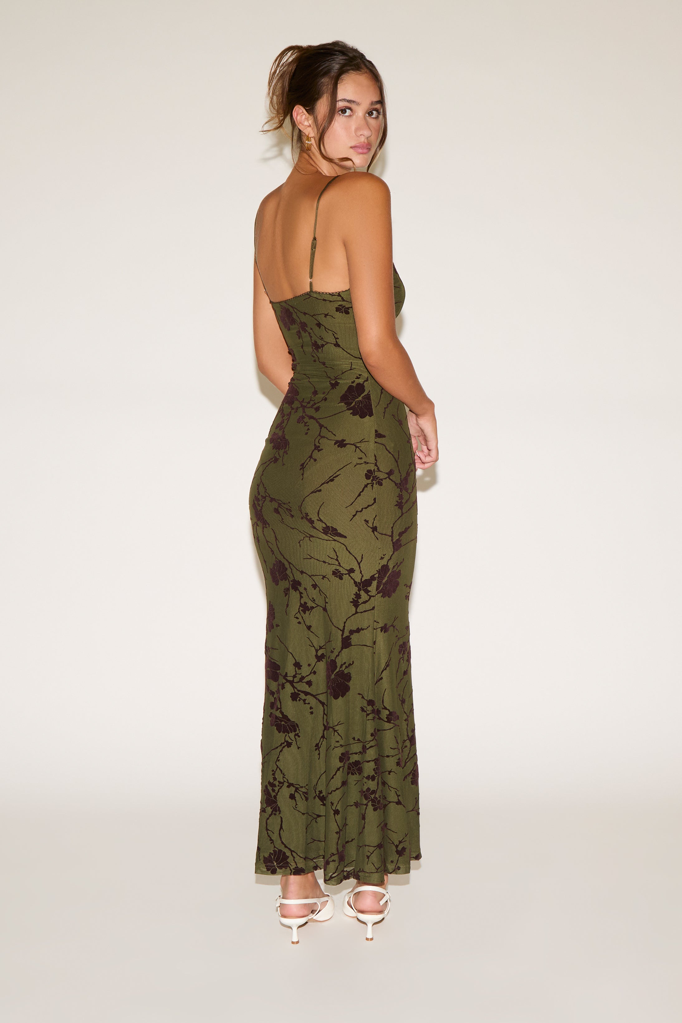 Woman wearing a green floral dress on a white background