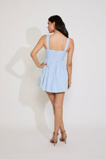 Woman wearing a light blue dress against a white background