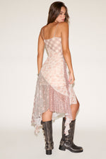 Woman wearing a floral dress and black boots on a white background