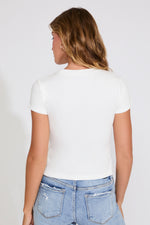 Person wearing a white t-shirt and blue jeans on a plain background