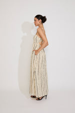 Woman wearing a long, patterned dress against a white background