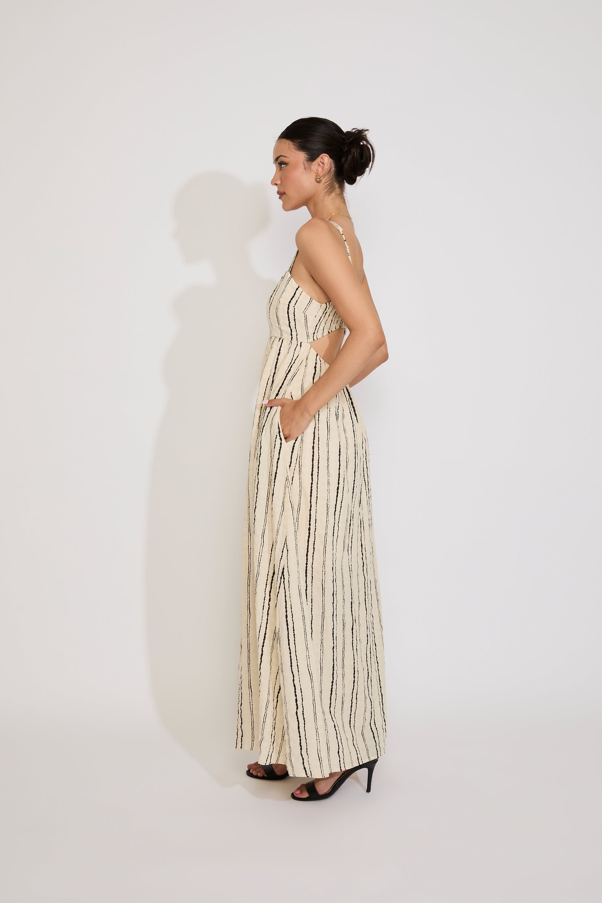 Woman wearing a long, patterned dress against a white background