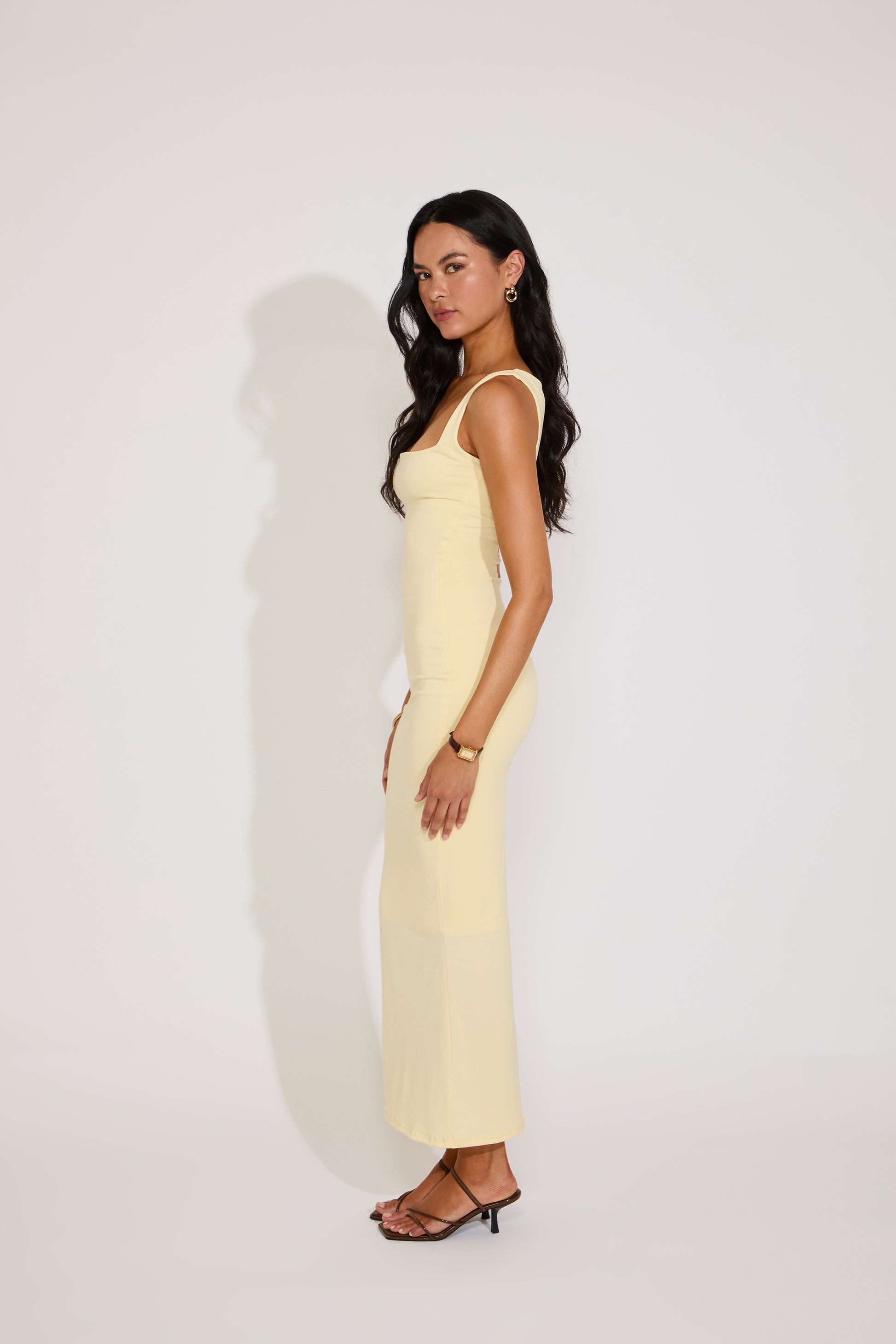 Woman wearing a light yellow dress against a white background