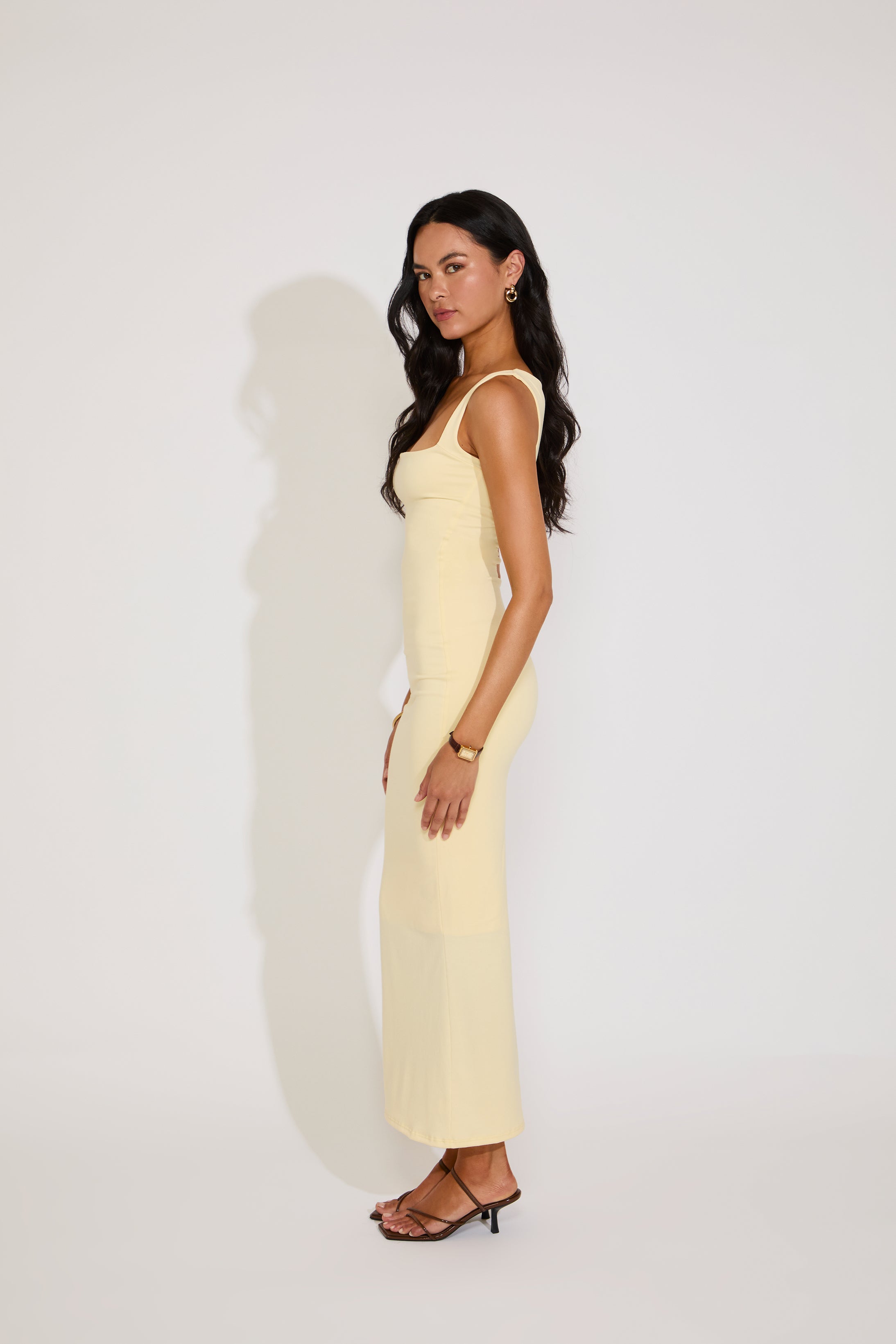 Woman wearing a light yellow dress against a white background