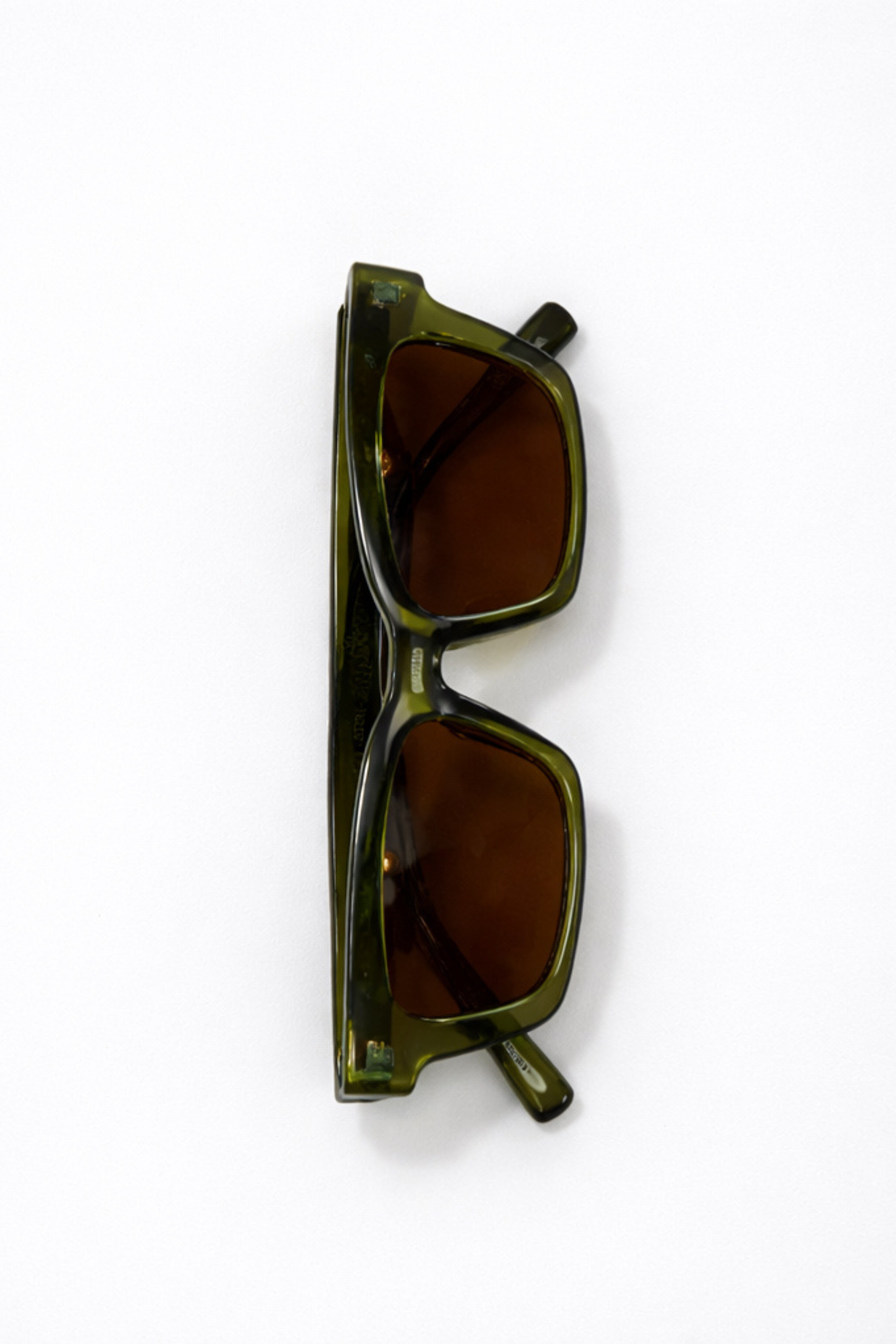 Green sunglasses with brown lenses on a white background
